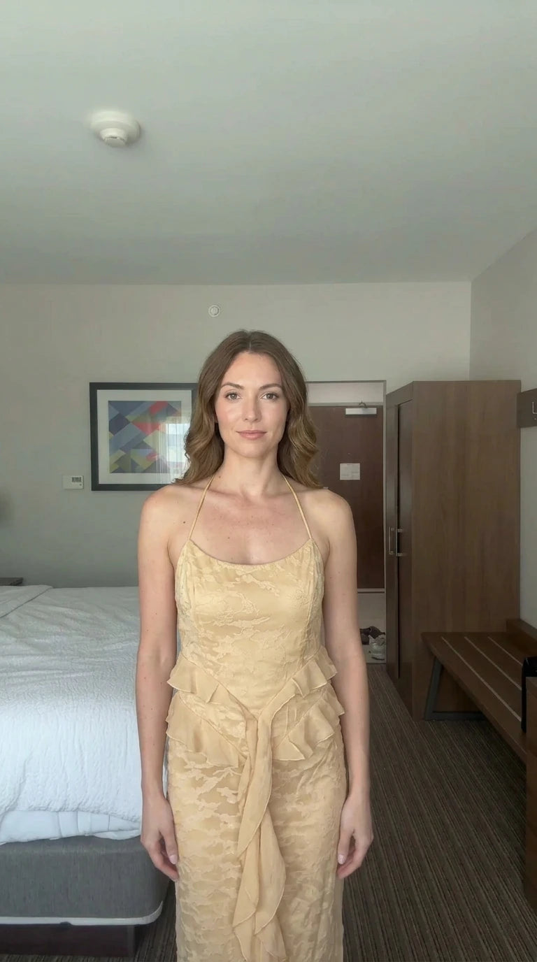Front view of woman wearing champagne gold floral jacquard halter maxi dress