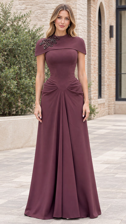 Front view of woman wearing burgundy beaded capelet mock neck evening gown