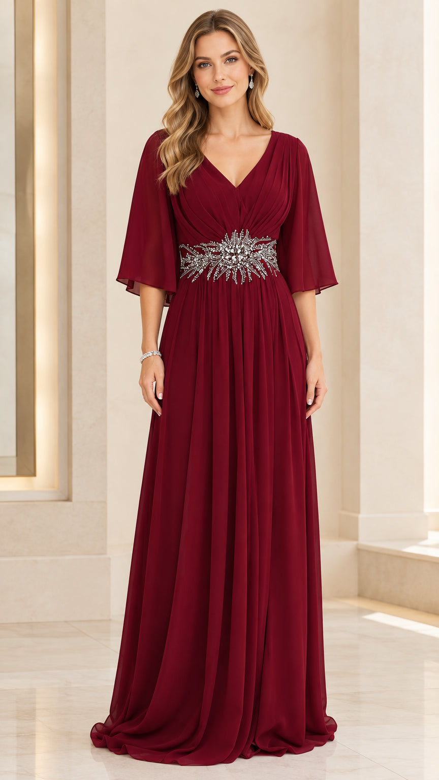 Front view of woman wearing burgundy flutter sleeve V-neck chiffon evening gown with beaded waist