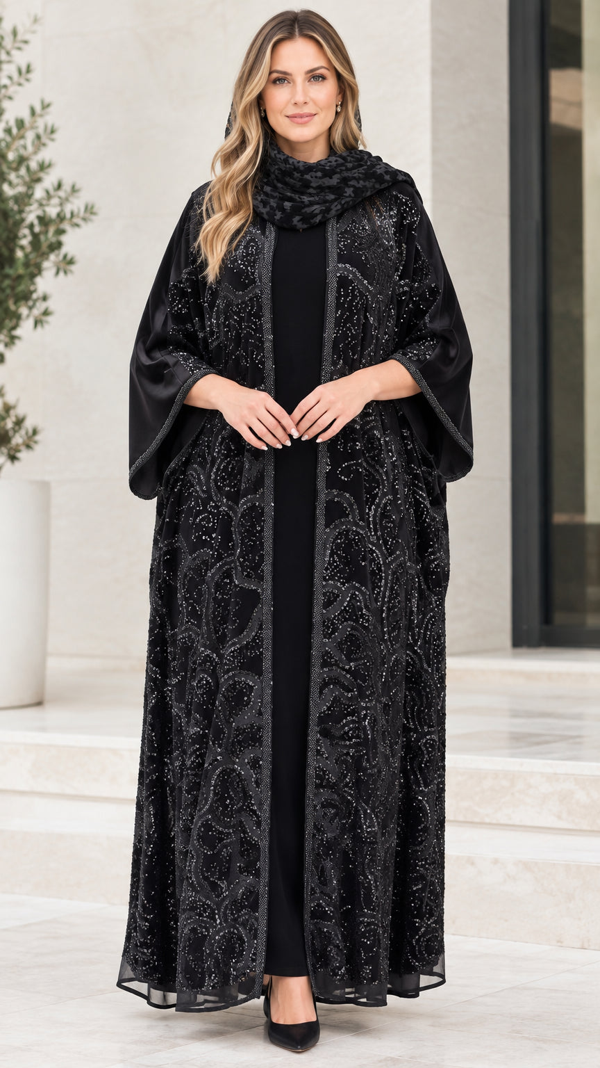 Front full-length view of model wearing black sequin embroidered open front abaya set with matching scarf