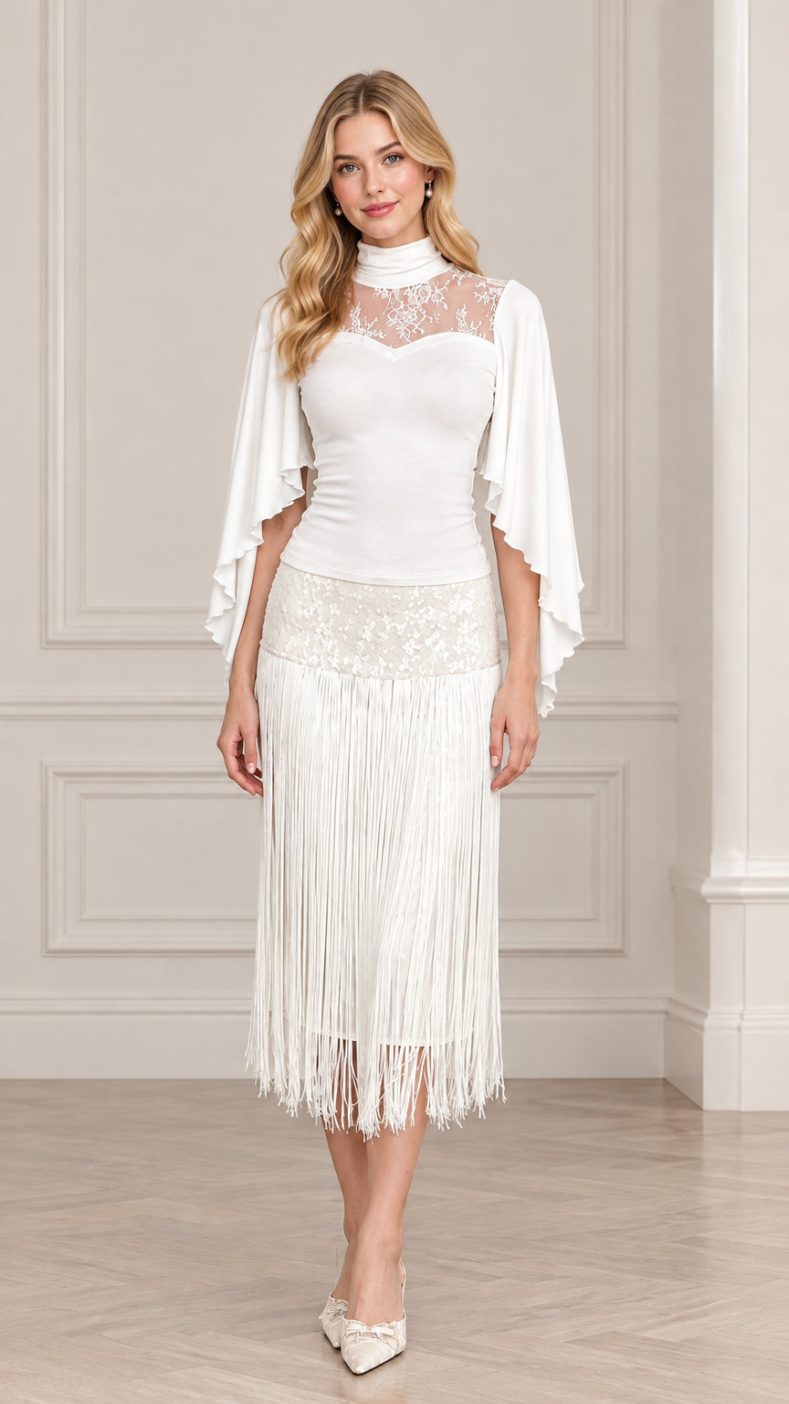 Front view of model wearing white mock neck illusion lace fringe midi dress with cape sleeves