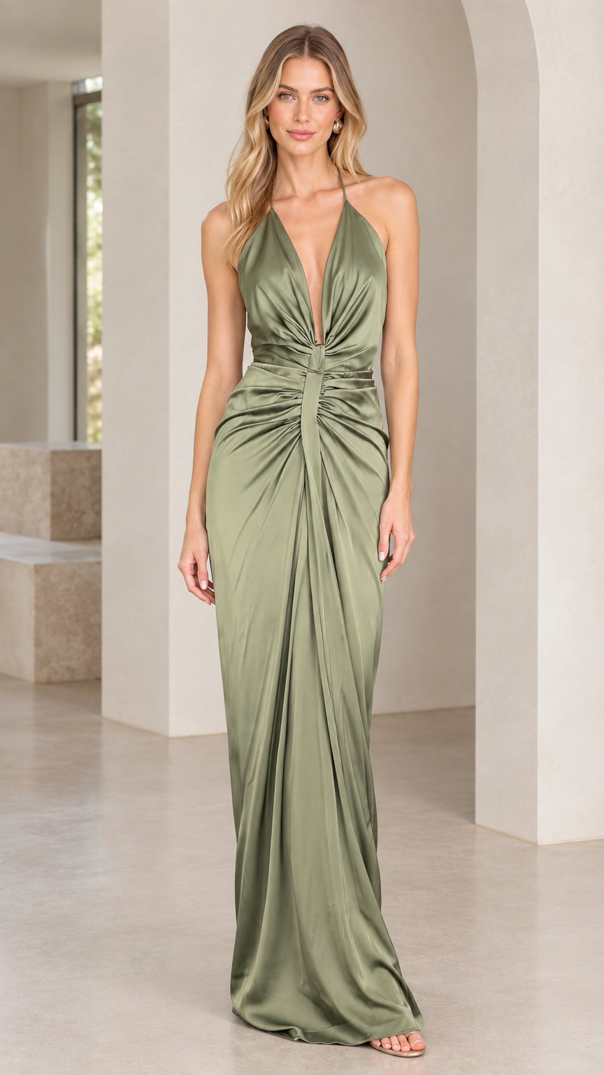Front view of woman wearing a sage green satin plunge halter maxi gown