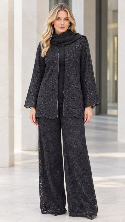 Front full-body view of model wearing black sequined floral lace pant suit set with matching scarf