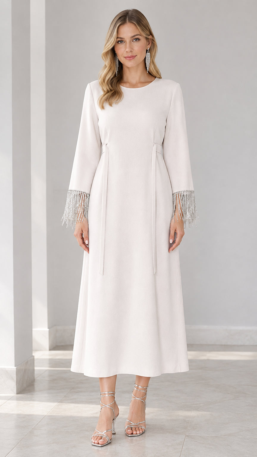 Front view of woman wearing white long sleeve maxi dress with rhinestone fringe cuffs