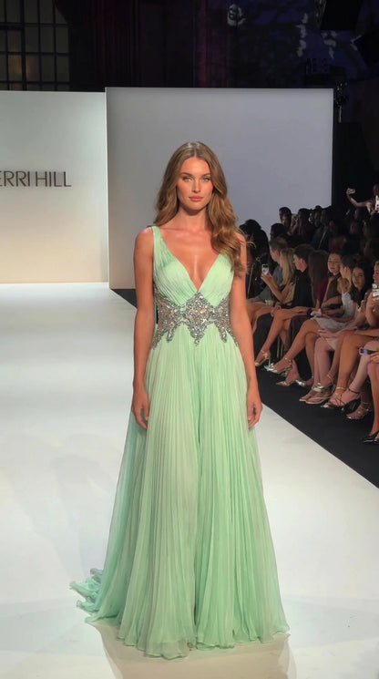Mint green pleated floor-length evening gown with a deep V-neck and embellished waist, front view