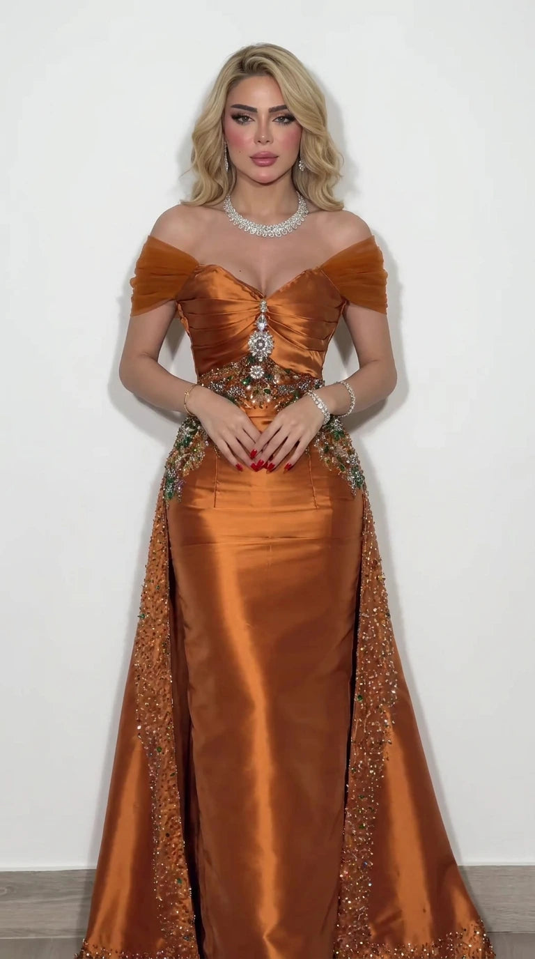 Front view of model wearing rust orange off-the-shoulder satin evening gown with beaded waist
