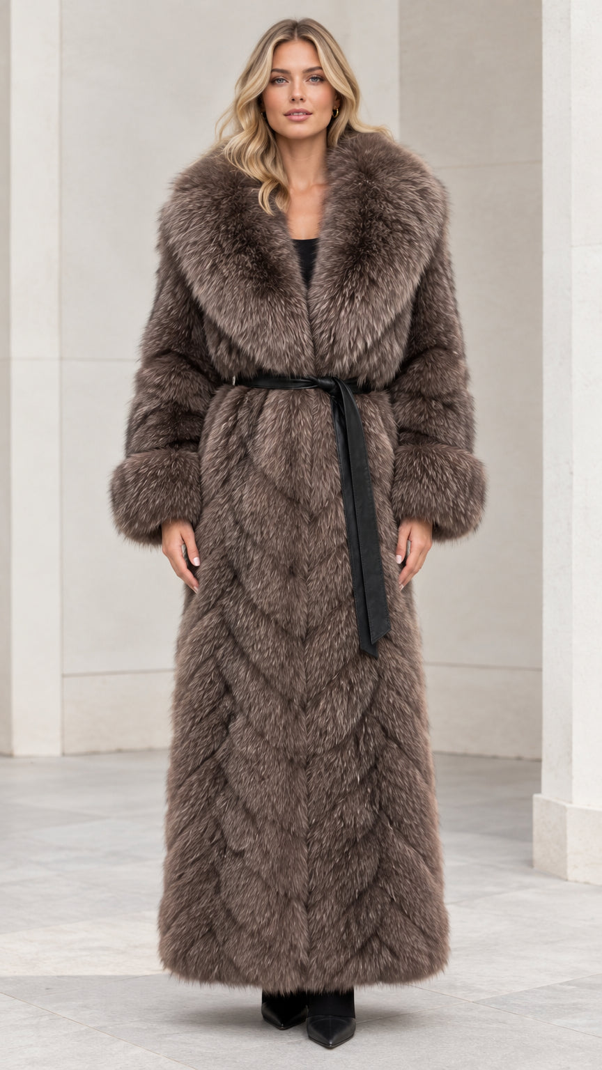 Front view of woman wearing taupe brown chevron faux fur maxi coat with black belt