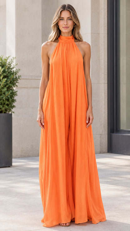 Front view of model wearing bright orange halter neck wide-leg flowy jumpsuit
