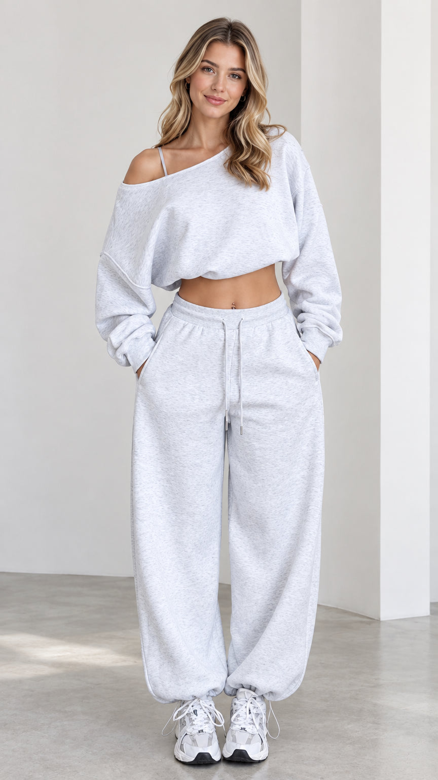 Front view of model wearing heather grey one-shoulder cropped sweatshirt and wide-leg sweatpants lounge set
