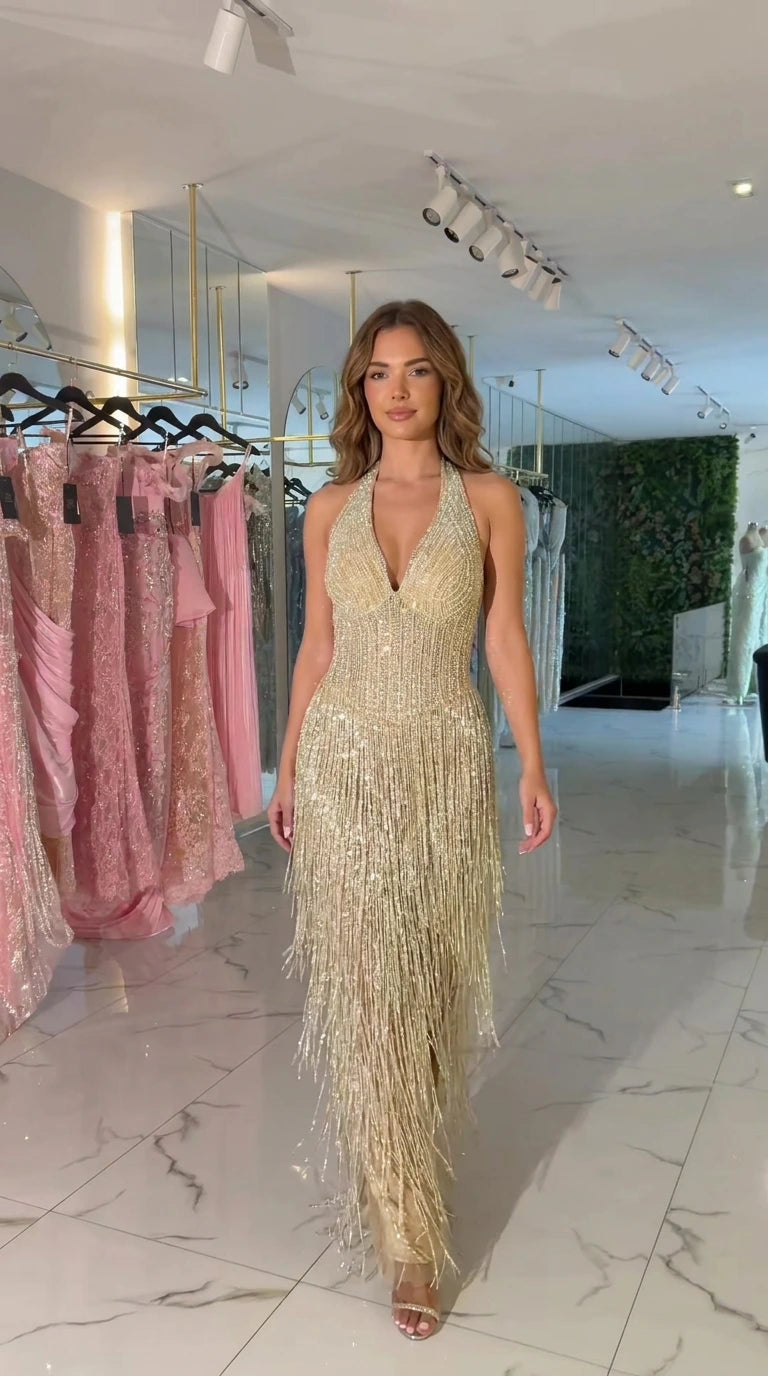 Front view of model wearing champagne gold halter beaded fringe maxi evening dress