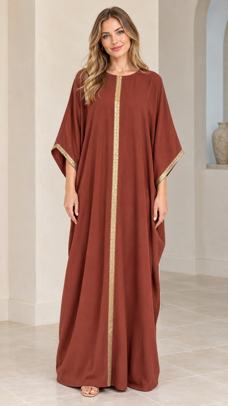 Front full view of woman wearing rust red kaftan maxi dress with gold metallic trim