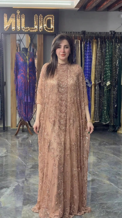 Front view of model wearing champagne hand-beaded cape maxi gown
