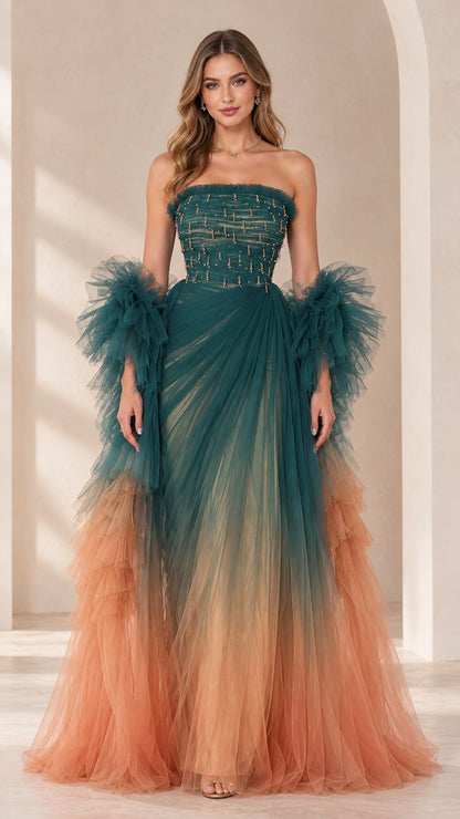 Front view of model wearing teal and peach ombre strapless beaded tulle evening gown with ruffled sleeve wraps