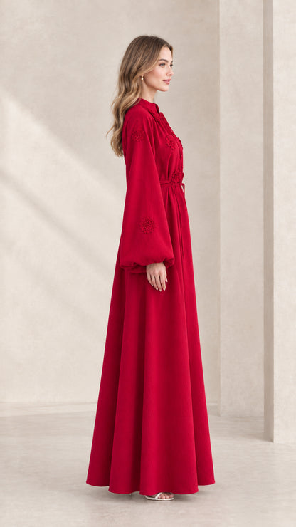 Side profile of model in full-length red modest maxi dress with floral appliqué