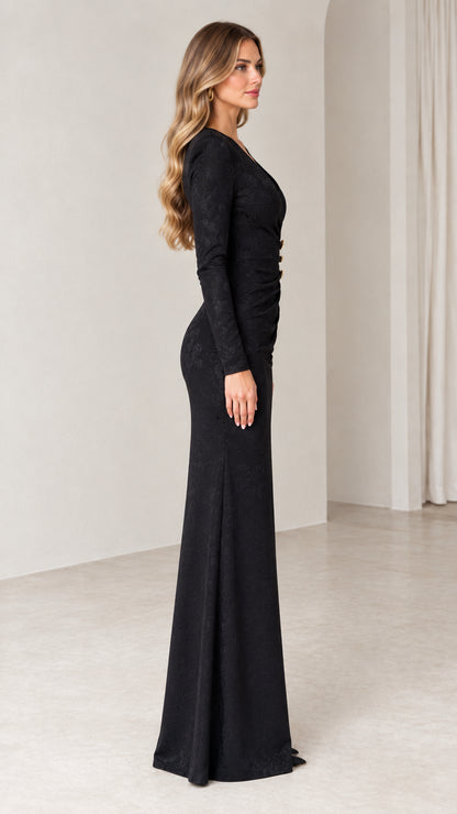 Side profile of woman wearing black long sleeve floor-length formal dress