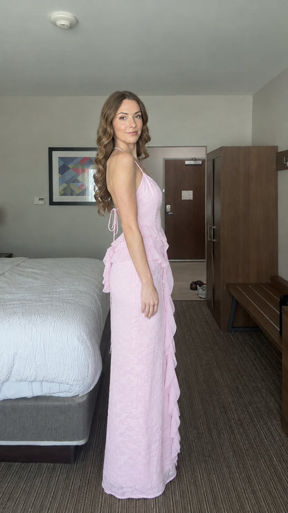Side view of woman wearing pastel pink floral halter maxi dress showing slim silhouette
