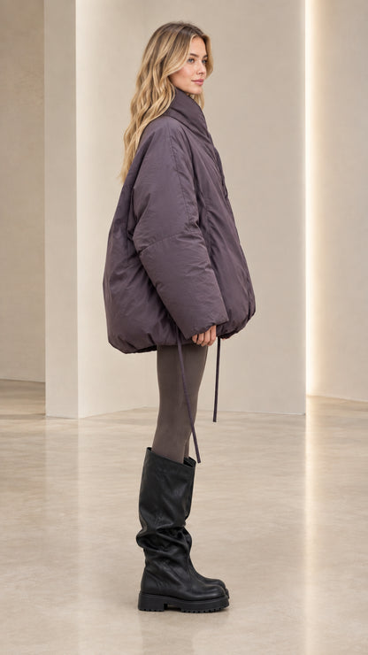 Side profile view of model wearing relaxed slate purple cocoon puffer coat