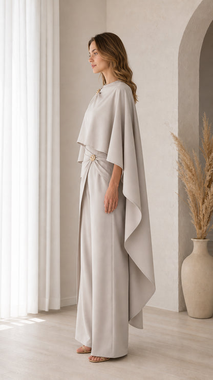 Side profile view of model in Light Grey draped cape top and floor-length trousers