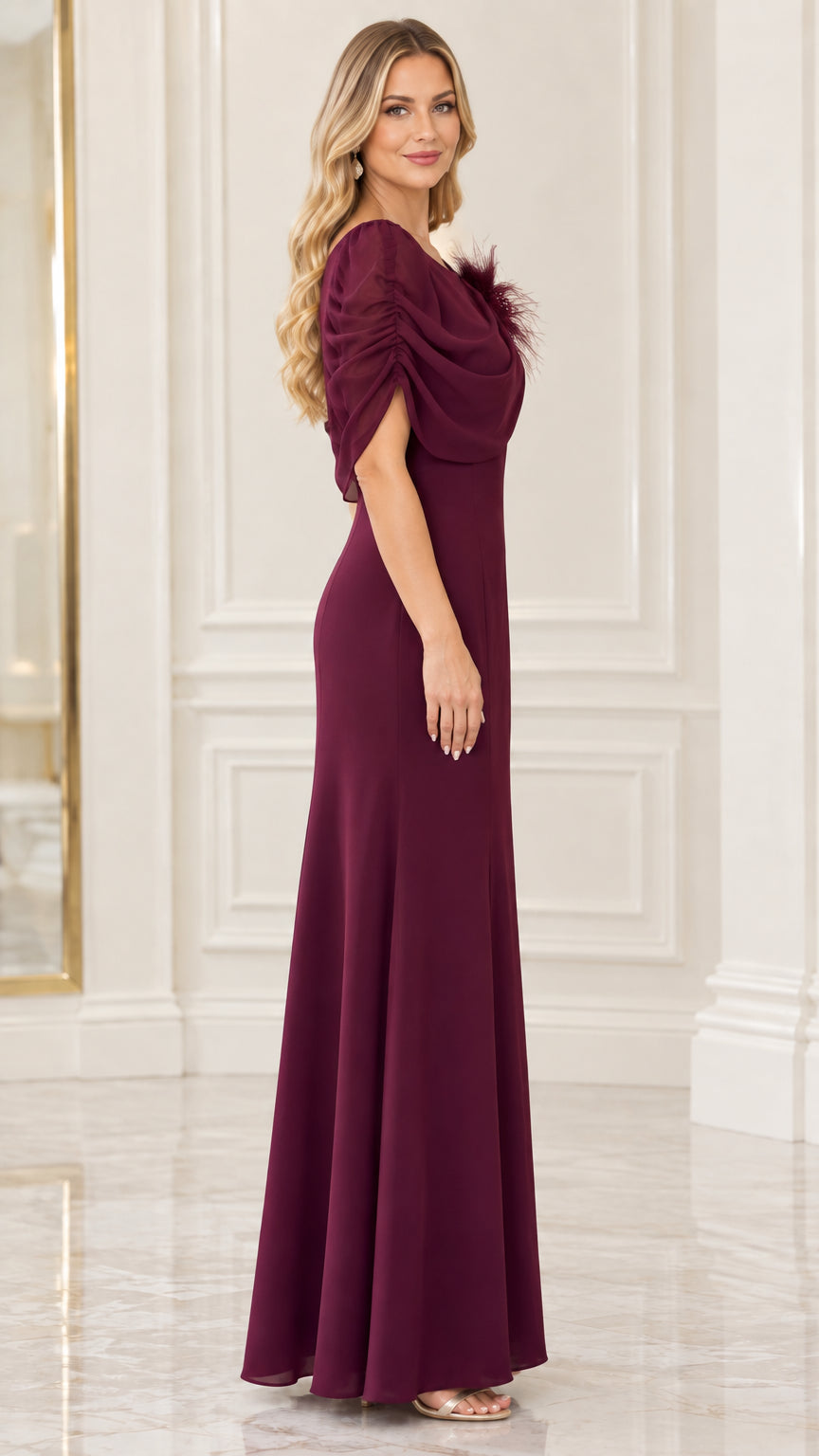 Side profile view of burgundy floor-length evening gown showing capelet sleeve and silhouette