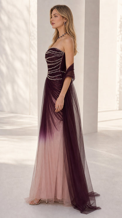 Side profile of the burgundy ombre strapless tulle gown showing fitted beaded bodice and skirt drape