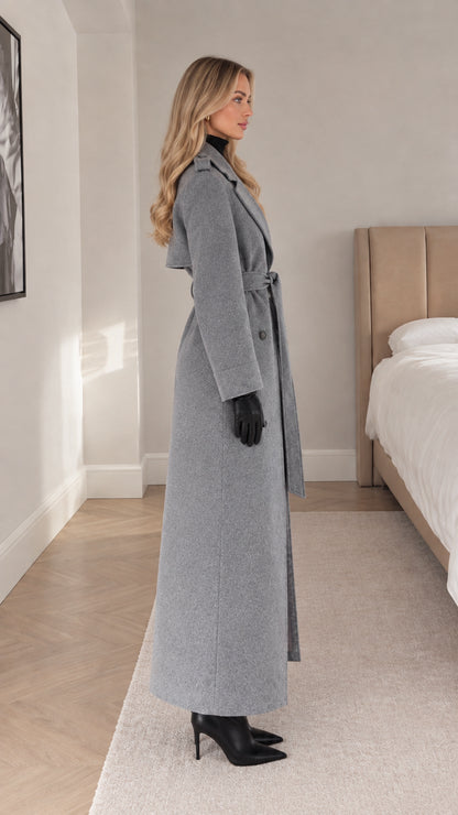Side profile of woman wearing full length grey trench coat