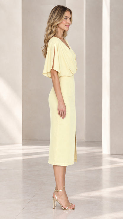 Side profile of model in pale yellow crossover v-neck midi sheath dress