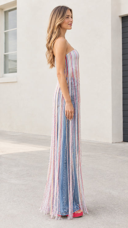 Side profile of model wearing strapless striped maxi fringe tube top showing full fringe length