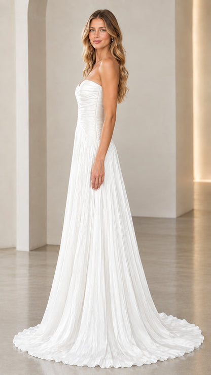 Side view of white strapless ruched maxi dress with flowing pleated skirt