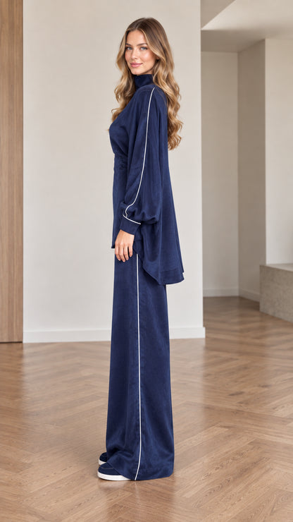 Side profile of women wearing navy blue high-low tunic and wide leg pants set