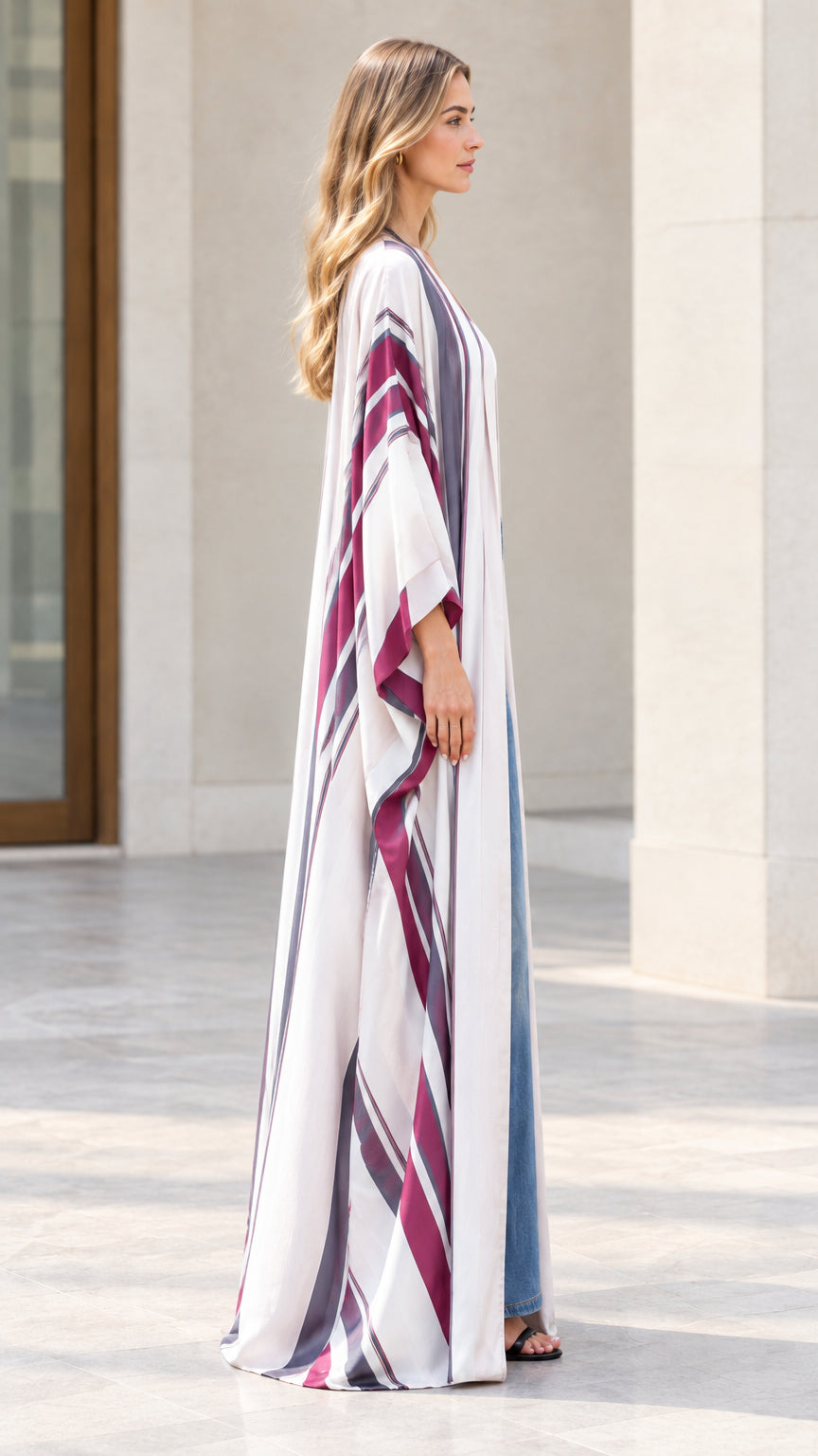 Side profile view of woman wearing flowing off-white striped maxi kimono cardigan