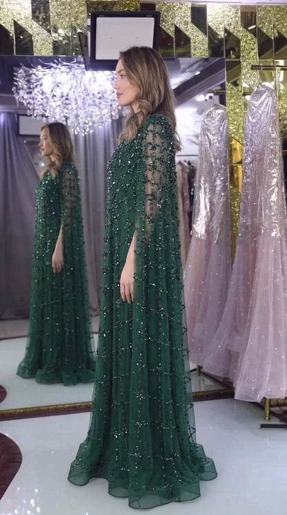 Side view of emerald green crystal embellished cape sleeve gown