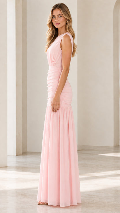Side angle view of blush pink fitted drop-waist pleated formal gown