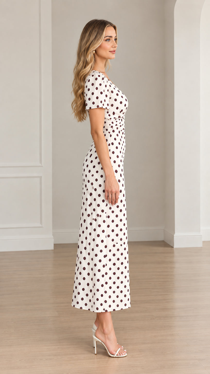 Side profile view of woman wearing white polka dot midi dress