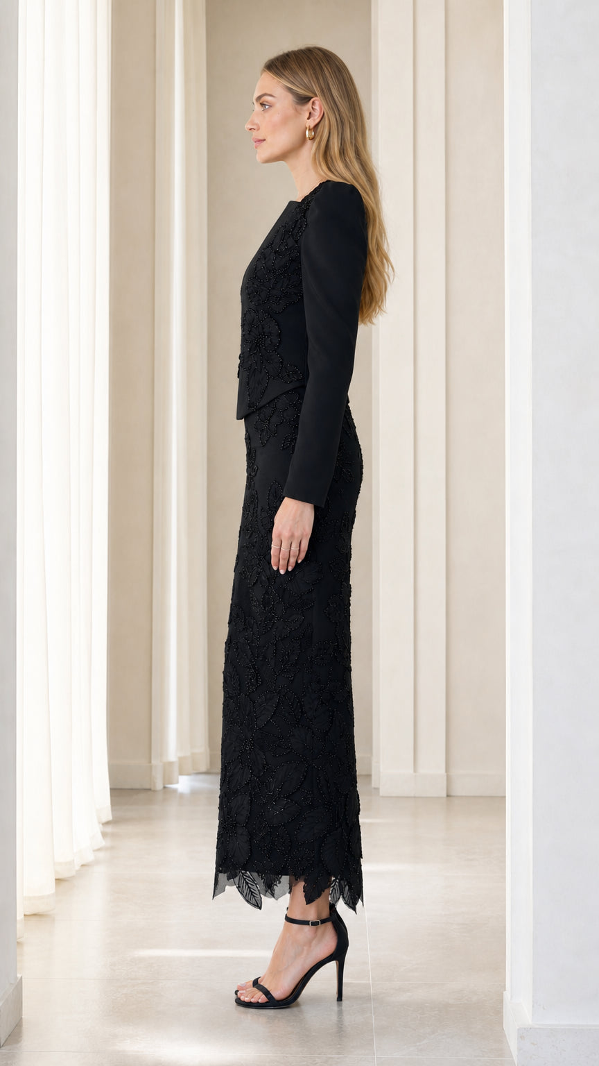 Side profile view of black long sleeve embroidered formal evening gown