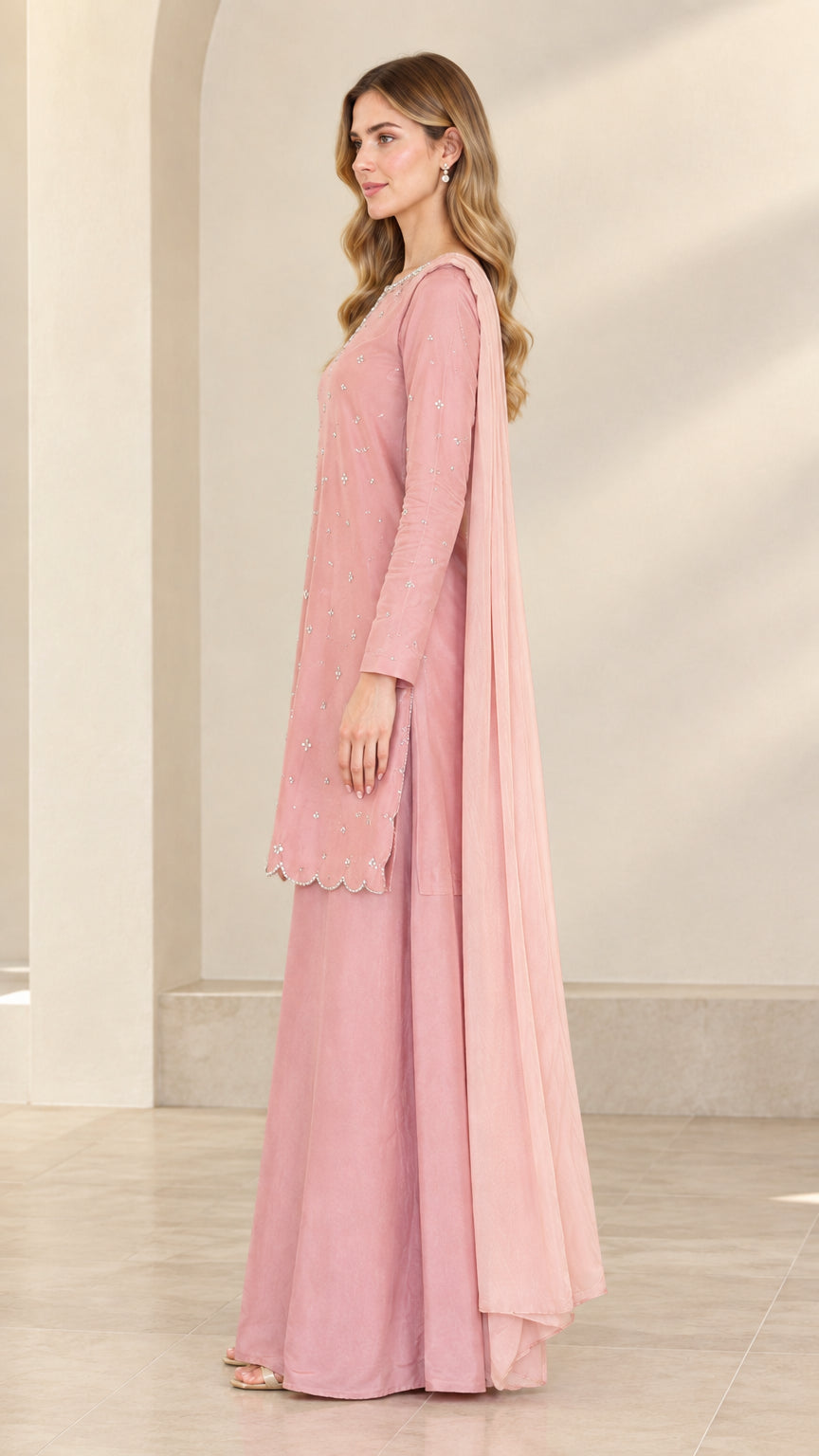 Side view of dusty rose long sleeve embroidered kurta and flowing palazzo pants
