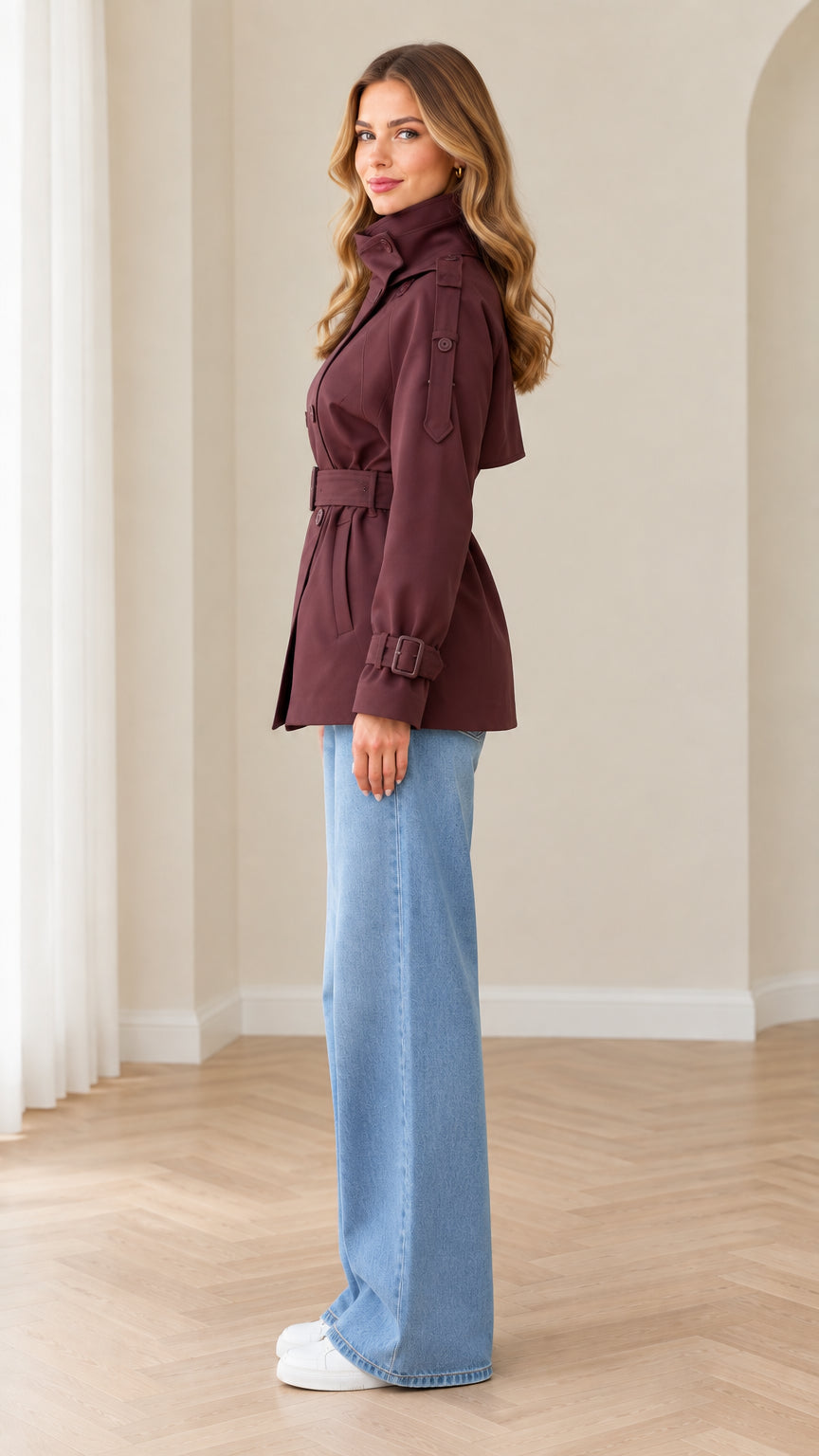 Side profile view of burgundy short trench coat paired with wide leg jeans