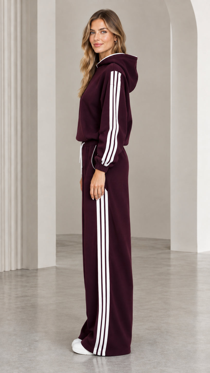 Side view of burgundy striped hoodie and wide leg sweatpants showing side stripe detail