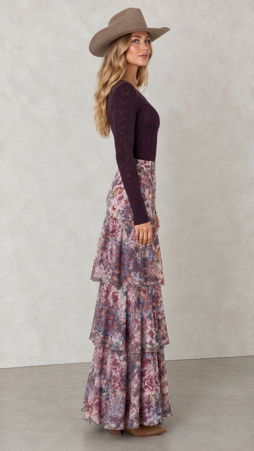 Side profile view of woman wearing flowy tiered floral maxi skirt with boots