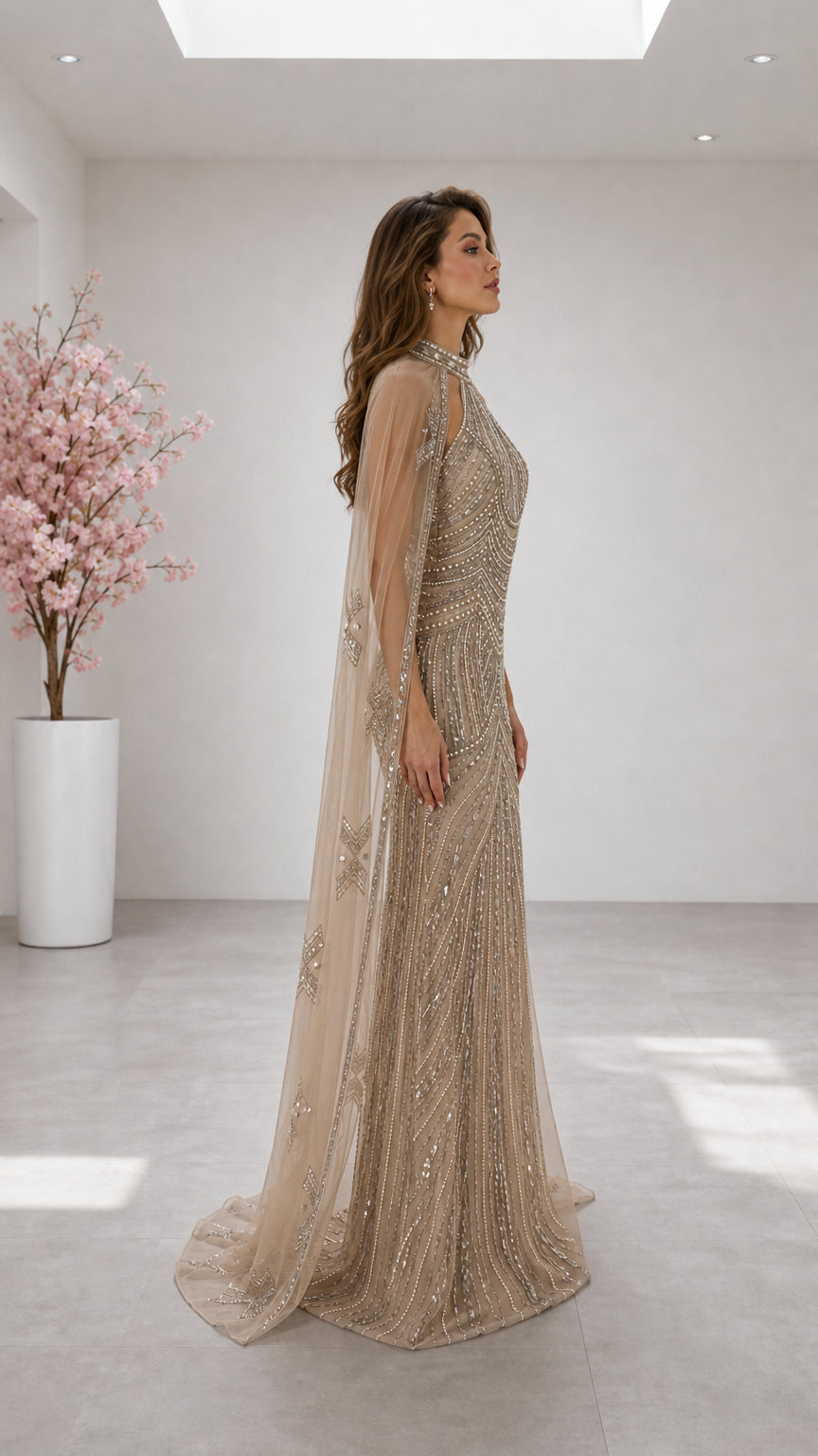 Side profile of woman wearing champagne sequin cape evening gown