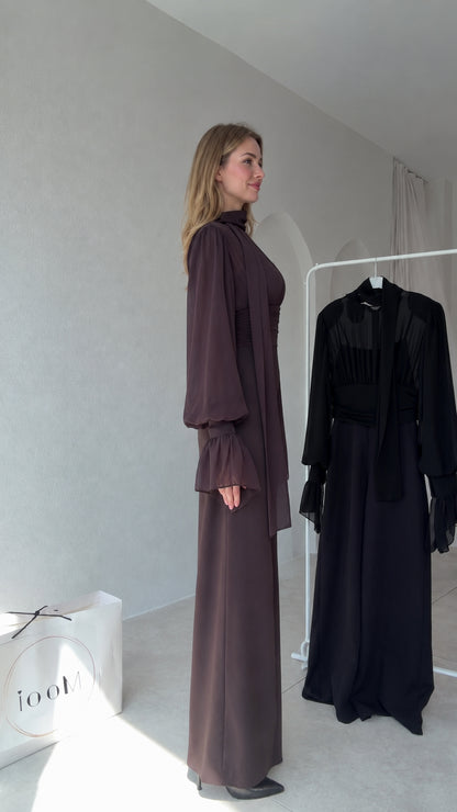 Side profile view of model wearing Chocolate Brown long sleeve wide-leg jumpsuit