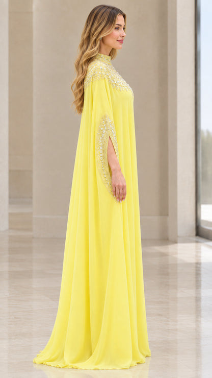 Side angle of model in flowing yellow beaded kaftan gown
