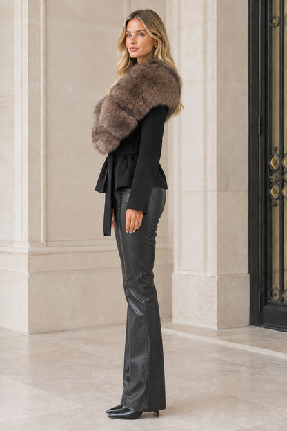 Side profile view of model wearing black belted faux fur collar jacket
