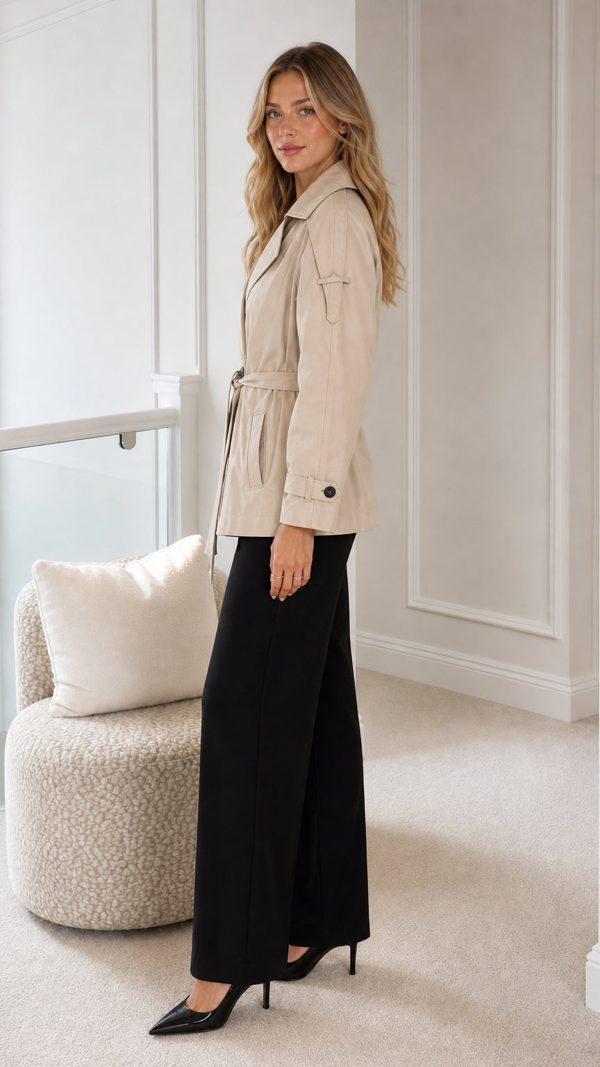 Side angle of beige short trench jacket with tie belt and cuff button details