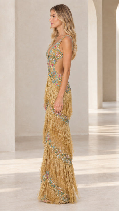 Side profile of gold embellished fringe formal dress showing back and cutout detail