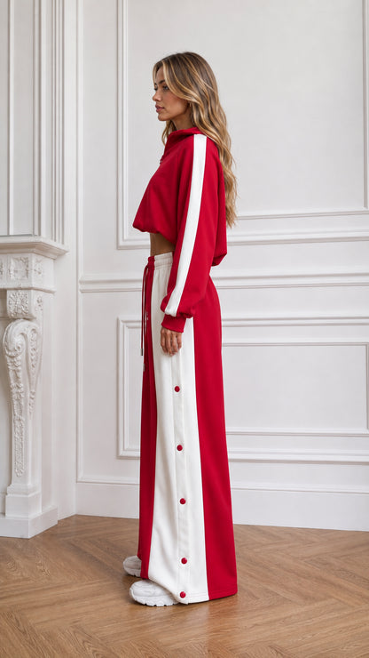 Side profile of woman in red two-piece athleisure set showing white side stripe details