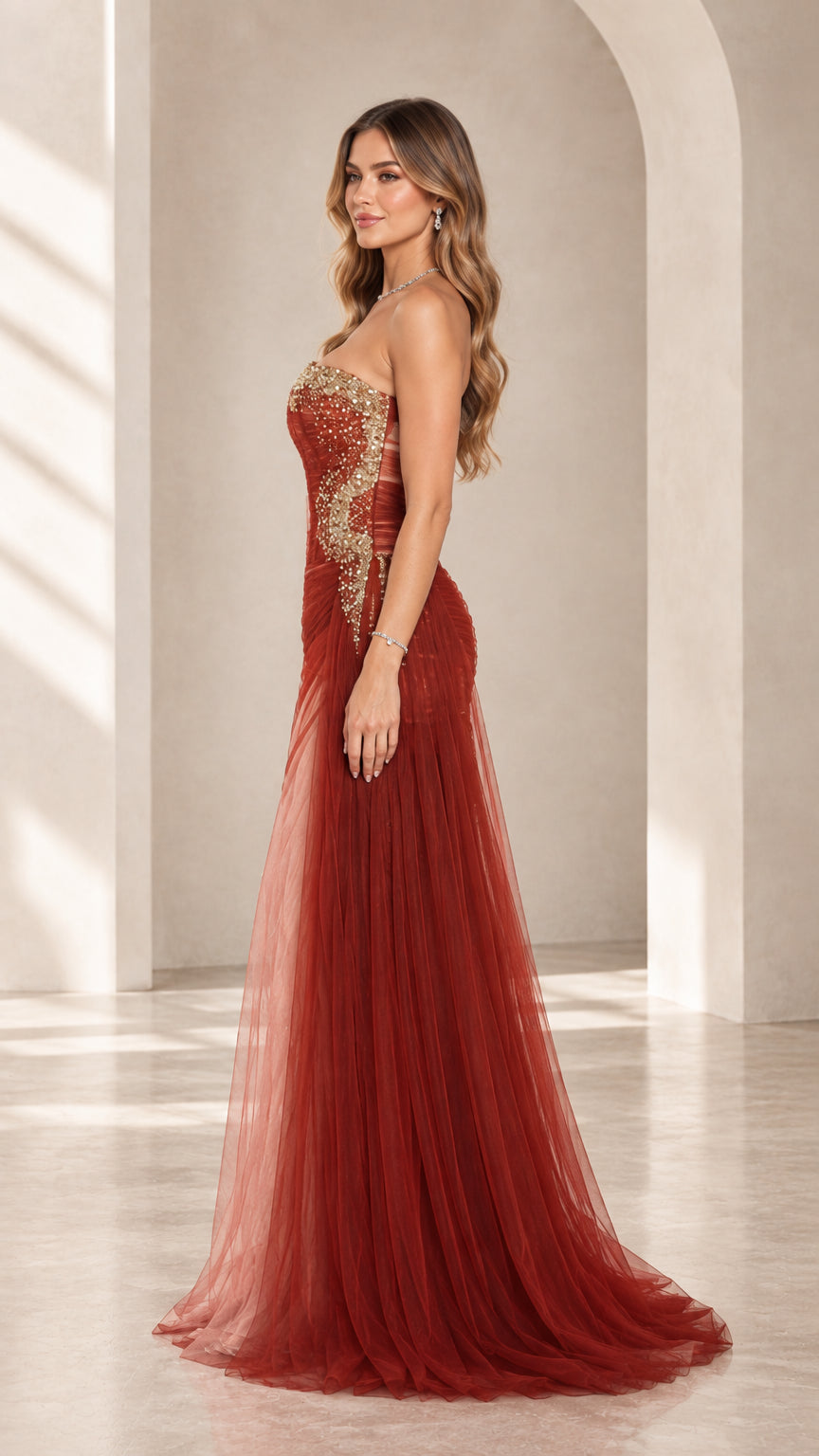 Side angle view of rust red pleated corset gown with flowing sheer tulle skirt