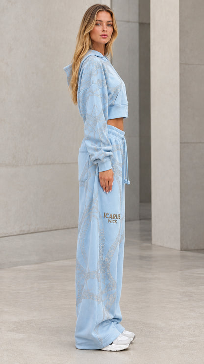 Side profile view of model in light blue two-piece glitter tracksuit set