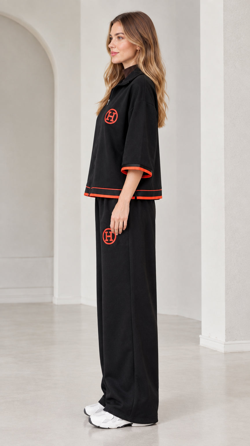 Side profile view of woman modeling black two-piece wide-leg tracksuit set