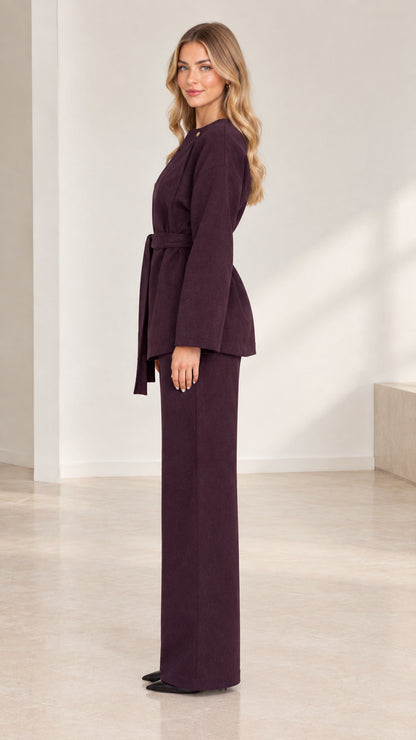 Side profile view of deep plum two-piece belted tunic and tailored wide-leg trousers