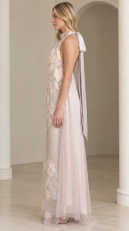 Side profile of woman in dusty lilac floral lace gown showcasing back ribbon tie
